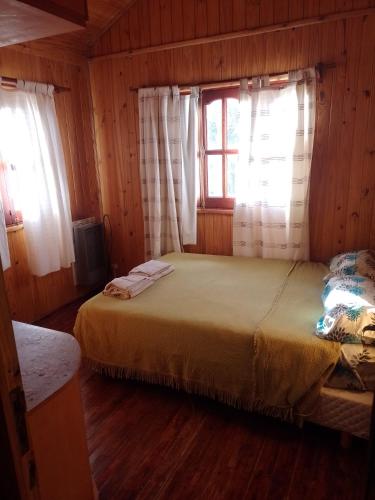 El MaiténCabañas maiten的一间卧室配有床和带窗帘的窗户