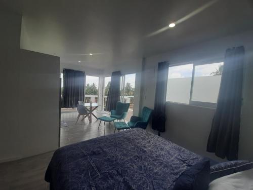 阿瓦鲁阿Mai'i Villa 2 - Muri的一间卧室配有一张床、一些椅子和窗户