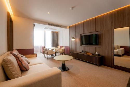 乌隆他尼Hotel MOCO的酒店客房设有沙发、电视和桌子。