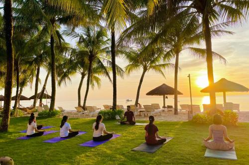 富国法米亚纳Spa度假酒店的一群人在海滩上做瑜伽