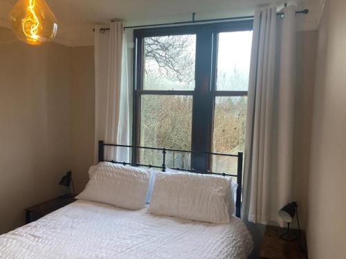 金尤西Uist Cottage的一间卧室设有一张床和一个大窗户