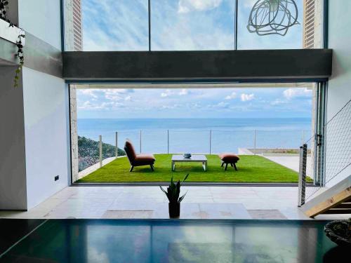 科孚镇Amberton Green Villas Corfu的客房设有带桌椅的大窗户。