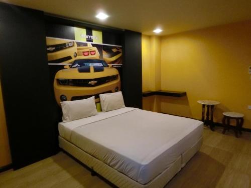 Ban KoNewYork Suite Hotel的卧室配有一张床和一张汽车海报