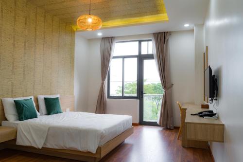 岘港Bambu Hotel的一间卧室设有一张床和一个大窗户