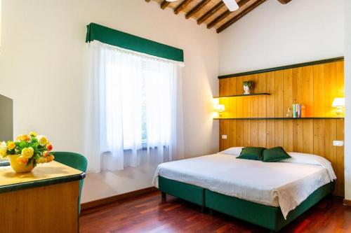 帕贾尼克Il Casale delle Rose的一间卧室设有一张大床和一个窗户。