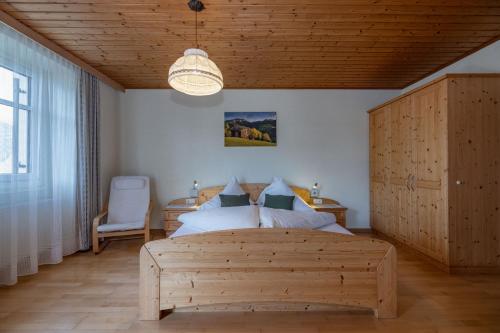 Sankt Lorenzen im Lesachtal呃勒本斯沃特格鲁伯酒店的一间卧室设有一张木床和木制天花板