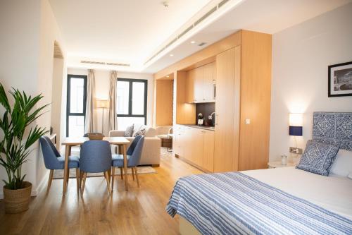 塞维利亚nQn Aparts & Suites Sevilla的酒店客房带一张床、一张桌子和椅子
