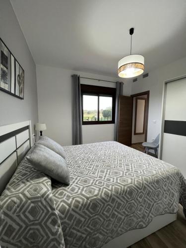 AljucénCasa Rural "El Cañuelo"的一间卧室设有一张大床和一个窗户。