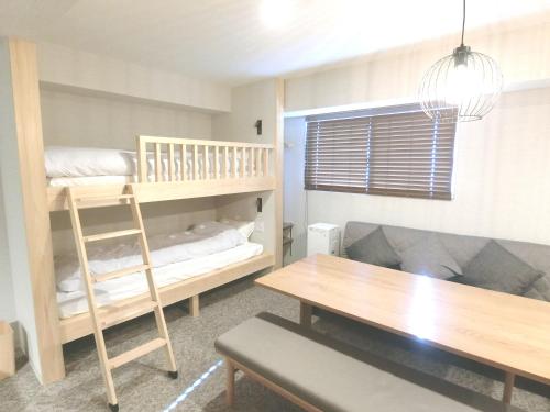 东京KLASSO Tokyo Sumiyoshi Apartments的客房设有双层床和桌子。