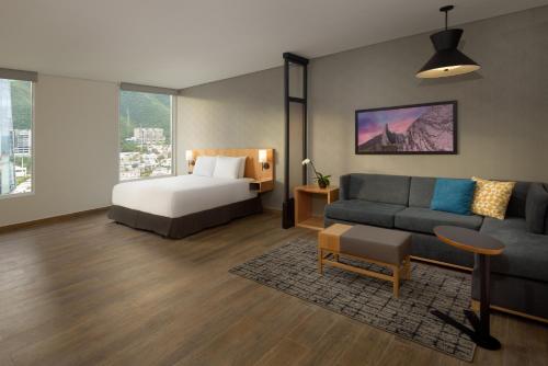 蒙特雷Hyatt Place Monterrey Valle的客厅配有床和沙发