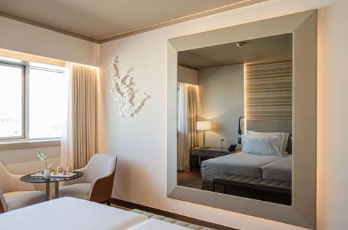 里斯本EPIC SANA Marquês Hotel的一间卧室配有一张床和镜子
