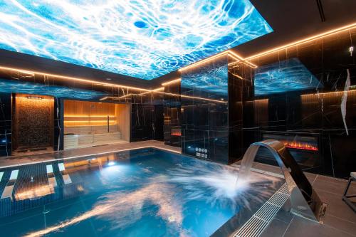 里斯本EPIC SANA Marquês Hotel的游泳池位于一个充满灯光的天花板的房间