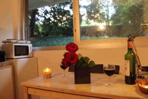 国玺Nice studio in the heart of Sceaux的一张桌子,上面放着两杯葡萄酒和一朵花