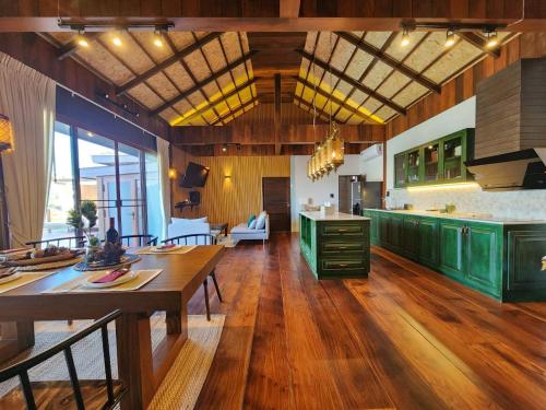考科Grand Kokkod Khao Kho Resort的一间铺有木地板并配有绿色橱柜的大厨房