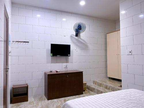 Thôn Tân HộiKhách sạn Ngọc Bích 2的一间卧室配有一张床,墙上配有电视