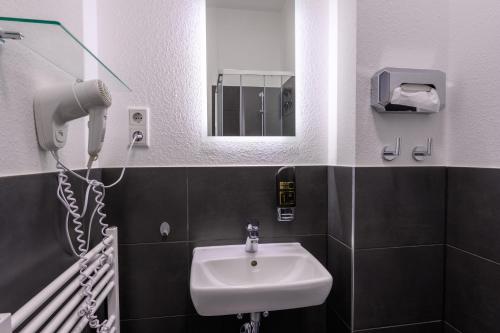 科隆Royale Apartaments Central City Cologne的一间带水槽和镜子的浴室