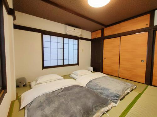 东京KIKI HOUSE的带大窗户的客房内的两张床