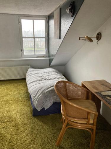 ZoeterwoudeLuc's place, Waterbed grote kamer的一间卧室配有一张床、一张桌子和一把椅子