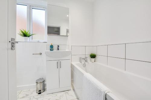 弗姆比Luxury 3-Bedroom House In Formby的白色的浴室设有浴缸和水槽。