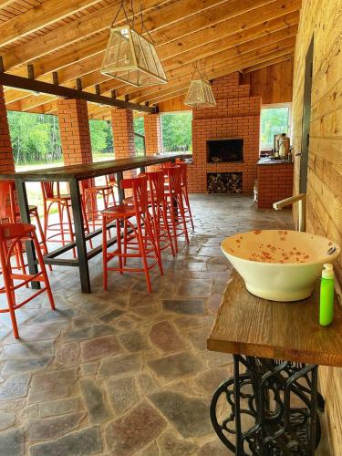 LisoveСадиба Бабина Лоза的一间设有红色椅子和桌上碗的酒吧的房间