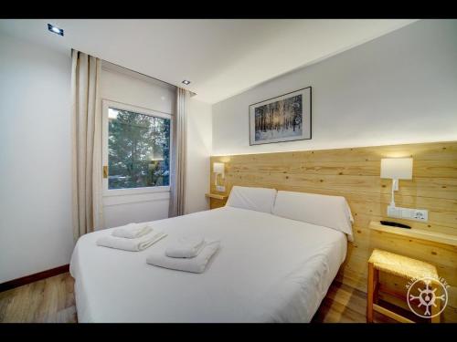 巴奎伊拉-贝莱特MONTLUDE de Alma de Nieve的卧室配有白色的床和2条毛巾