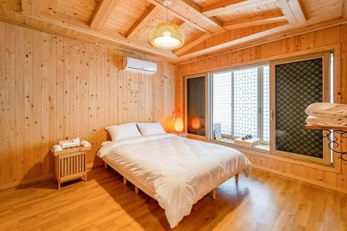 丽水市Elon Hanok Pension的一间带一张大床的卧室,位于带木墙的房间