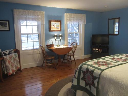 Granville FerryGrand Oak Manor Bed and Breakfast的卧室配有一张床和一张桌子及椅子
