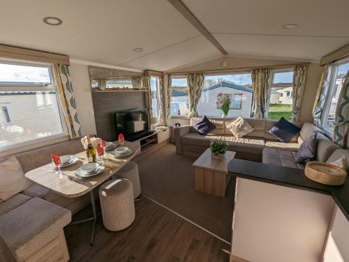 韦茅斯Sleeps 6 Modern and bright Caravan Littlesea Haven Weymouth的客厅设有大篷车内的沙发和桌子