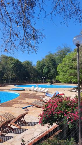 HohenauCasa de huéspedes Mariposa en manantial countryclub的公园里一个带椅子和鲜花的游泳池