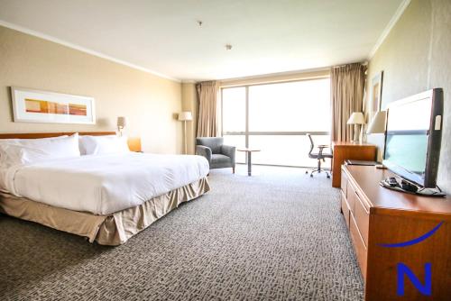蒙特港Novotel Puerto Montt的配有一张床和一台平面电视的酒店客房