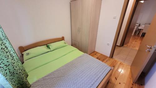 兹拉蒂博尔Zlatibor Apartmani DM Tornik的一间小卧室,配有一张带绿色床单的床