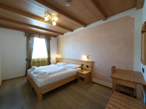 SporminoreAgritur Sandro的一间卧室配有一张大床和一张桌子
