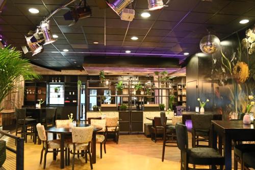 BlesdijkeGlamplodge met privé sanitair的餐厅设有桌椅和紫色天花板。