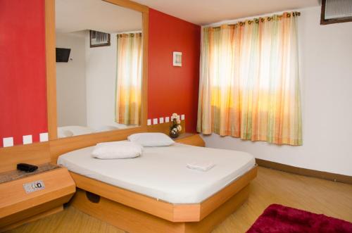 里约热内卢Jumbo Hotel (Adults Only)的一间卧室设有一张床和红色的墙壁