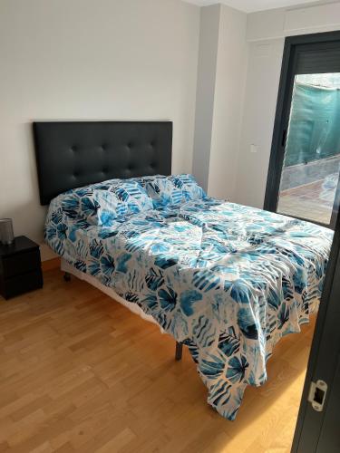 马德里Loft_Luminoso_Efeso的卧室内的一张带蓝色和白色棉被的床