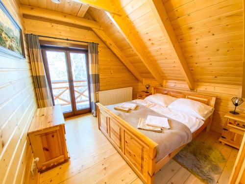 米德尔布罗齐齐耶维奇Góralska Willa Bajka的小木屋内一间卧室,配有一张床