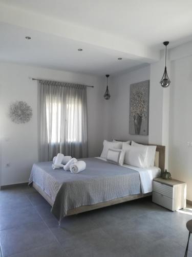 依诺罗达Aiolos Blu Luxury Apartments的白色卧室配有一张带白色枕头的大床