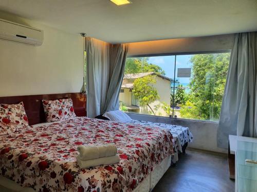 马塞约Villas do Pratagy resort Maceió próximo praia的一间卧室设有一张床和一个大窗户
