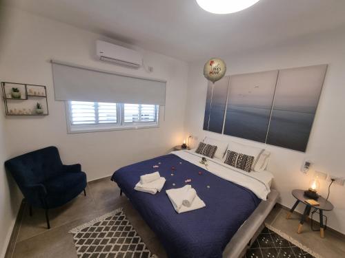 内坦亚Beautiful 2-Bedroom Sea-View apartment的一间卧室配有一张大床和一张蓝色椅子