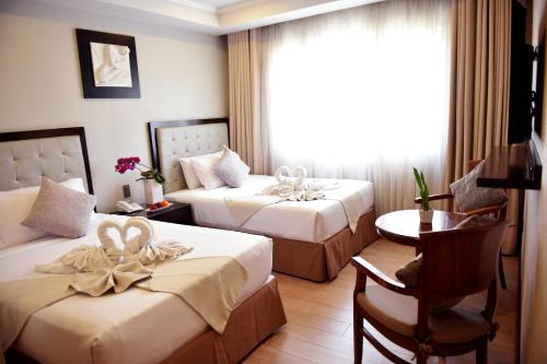 碧瑶Aura One Hotel的酒店客房设有两张床和一张桌子。