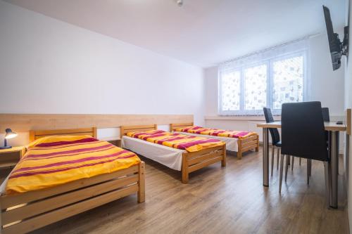 捷克布杰约维采Hotel U Nádraží的配有两张床铺的客房配有桌椅