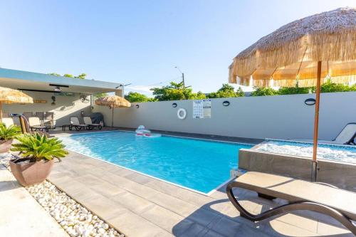 多拉多Aquaville Dorado Moderna Villa 1的一个带长凳和遮阳伞的游泳池
