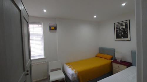 West MoleseyMolesey near Hampton Court, Viking Short Stays的一间设有黄色床和窗户的小卧室