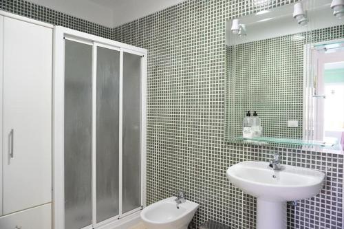 圭马尔港South Coast Apartment的一间带水槽和玻璃淋浴的浴室