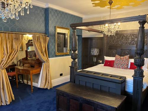 莫尔登Staycations Maldon的一间卧室配有一张天蓬床和一张书桌