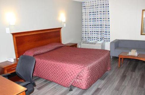 奥尔巴尼Araamada Inn的酒店客房配有红色的床和椅子