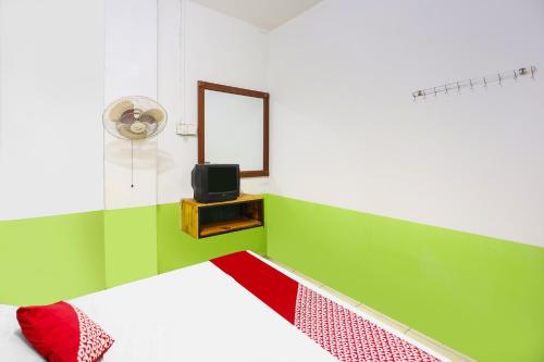 丹戎槟榔SPOT ON 92053 Bagus Stay的一间卧室配有一张床、镜子和电视