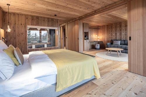 伦策海德Valbella Resort的一间带一张大床的卧室,位于带木墙的房间