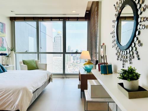 曼谷The river luxury two bedrooms的一间卧室配有一张床和一张带镜子的书桌