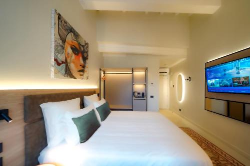 贝加莫Bergamo INN 21的配有一张床和一台平面电视的酒店客房